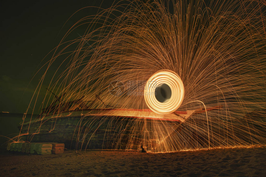 在海滩上燃烧的钢羊毛所产生效应旋转时图片
