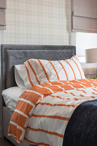 现代卧室的单张床橙色和白色调背景图片