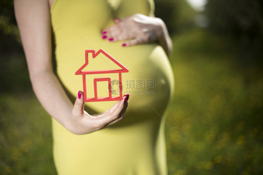 孕妇在户外手持房屋形象的裁剪图像图片