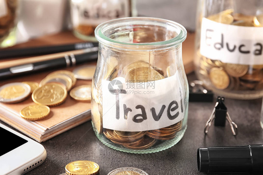 玻璃罐上面有旅行储蓄和硬币图片