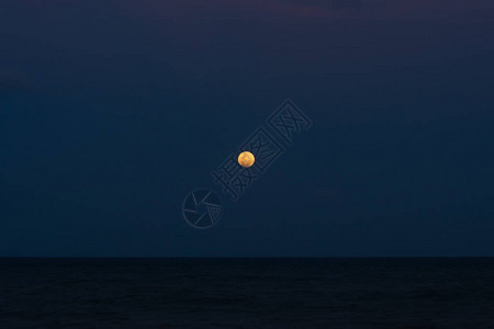 超蓝血月蚀在海面上的黑夜图片