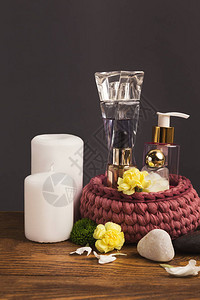 水疗瓶组成的水疗精华芳香油香水和鲜花灰色背景侧视图复制空图片