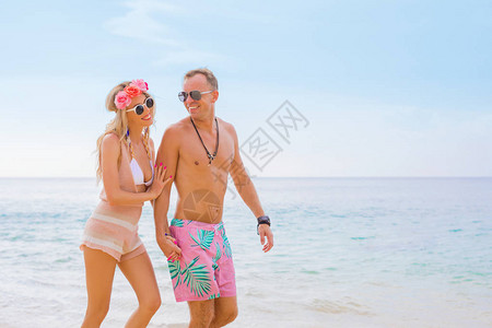 幸福的情侣在沙滩上散步图片