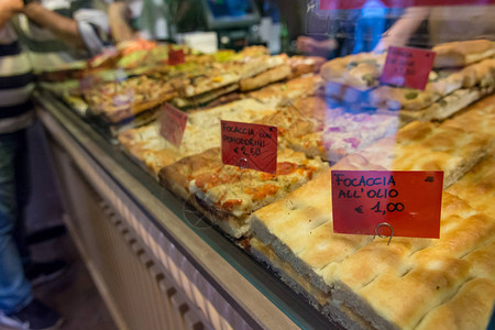 当地面包店出售美味的比萨饼和focaccia面包图片