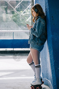 高筒使用智能手机的耳机衣物高袜子和溜冰鞋中的背景