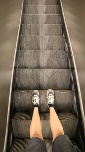 现代购物中心扶梯和带有短裤和运动鞋的图片