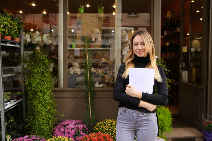 花店经理站立在报纸上花卉生意和房间工厂的概念图片