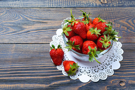 新鲜成熟的草莓放在木制桌上的碗里新图片