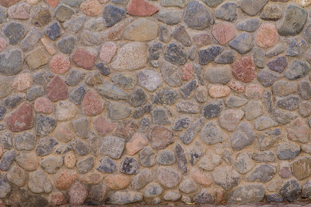 圆石古老石墙与灰色水泥的图片
