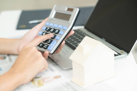 女会计师或银行工作人员在办公室使用计算器计算房屋贷款图片