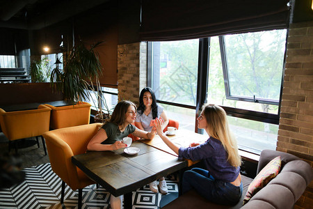 年轻女朋友在咖啡馆讲话图片