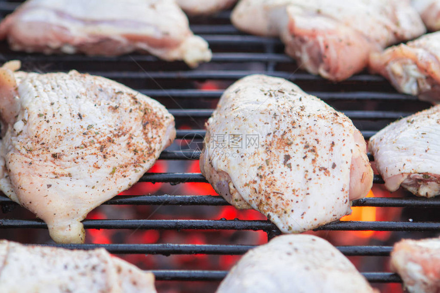 木炭烤架上的一些生鸡肉特写图片
