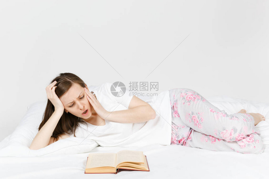 年轻不满意的女人躺在床上图片