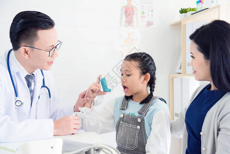 亚洲男医生向女孩解释哮喘吸入器的方法图片