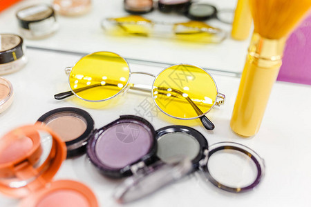 妇女化妆化妆和黄色亮光墨镜工具的顶图片