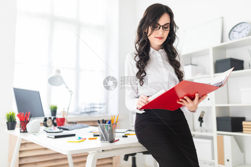 美丽的年轻女孩站在办公室图片