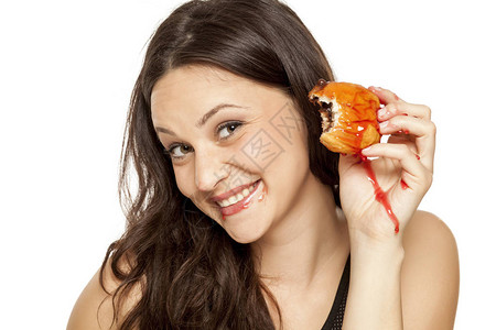 渴望在白色背景上吃樱桃馅甜圈的年轻女人图片