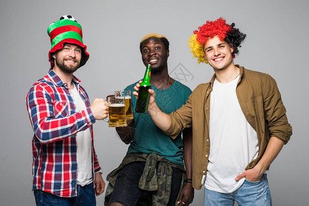 三名混血男球迷欢呼啤酒在白色背景下被隔离图片