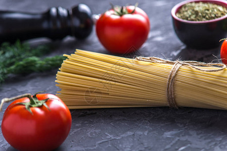 未煮过的意大利面食意大利面配上深色背景的番茄酱配料食品设图片