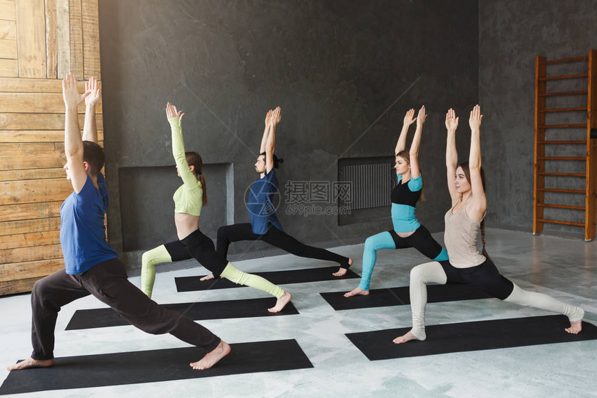 瑜伽课伸展和平衡练习中的年轻男女放松的英雄姿势健身俱乐部的健康生活方图片