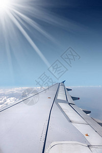 飞机翼通过左舷窗拍摄有蓝天空乌云图片