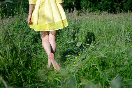 女赤脚在草地上行走年轻女子喜欢户外散步自然绿色图片