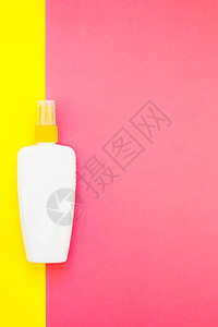 亮黄色和粉红色双调纸背景上的防晒霜空白瓶样机暑假创意平躺图片