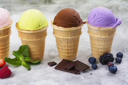 各种天然冰淇淋草莓巧克力橙子蓝莓和薄荷在绿色户外背图片