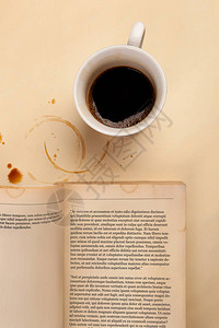 咖啡杯米色桌上的旧书有上面的污点图片