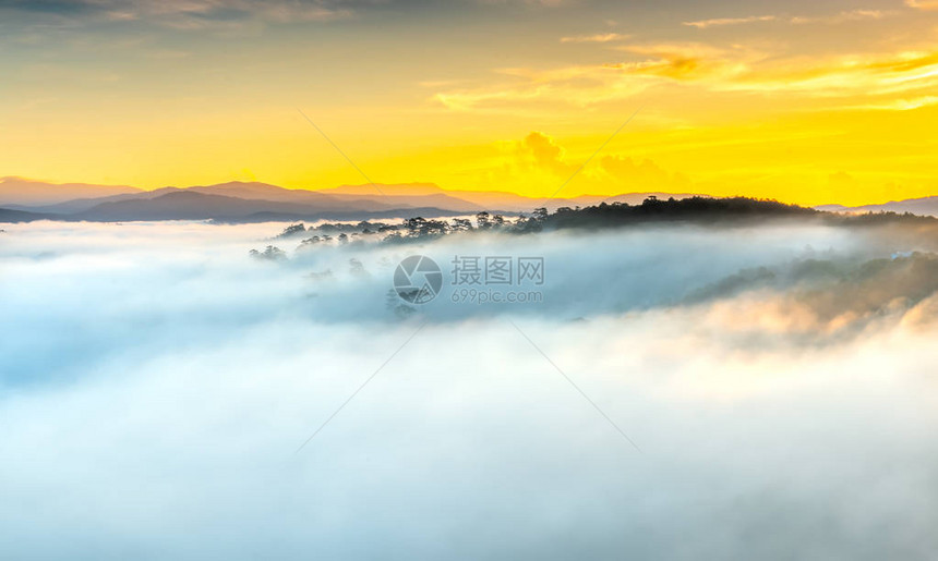 从地平线升起的太阳照耀着被雾笼罩的小村庄图片