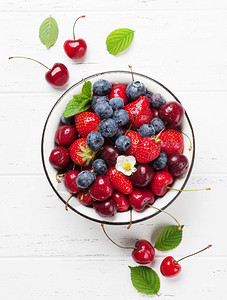 新鲜的夏季蓝莓樱桃和草莓在碗里顶视图图片