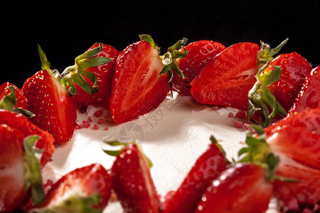 芝士蛋糕配草莓用草莓装饰的蛋糕用新鲜草莓装饰的美味芝士蛋糕黑色背景图片