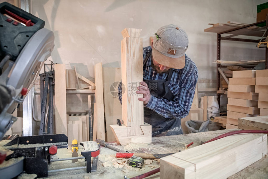 特写经验丰富的木匠在工作服和在木工车间工作的小企业主图片
