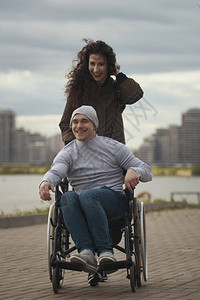 幸福情侣的肖像照顾身着轮椅残疾男子图片