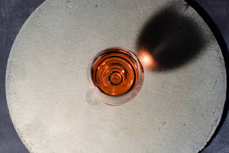 黑红酒在圆石桌上美丽的深红底彩色面粉图片