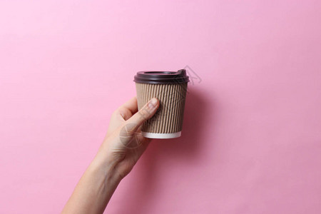 咖啡在纸板杯里手握着彩色背景的咖啡最图片