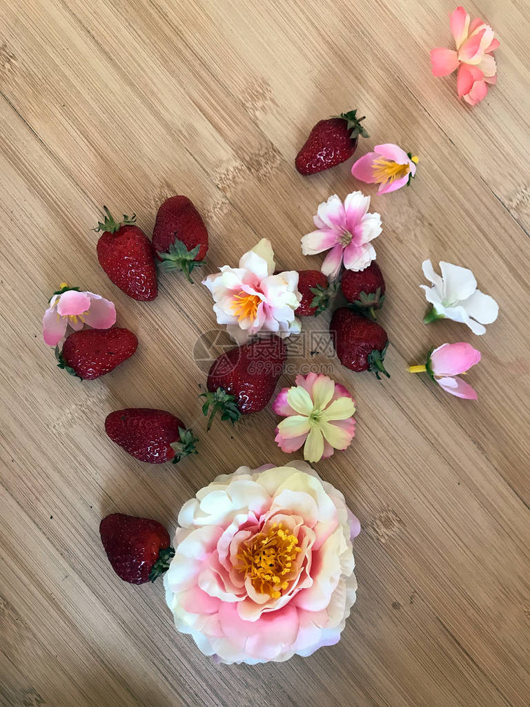 桌上有美味的草莓和美丽的花朵图片