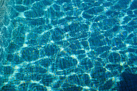 浅蓝色透明水的质地在泳池里离婚其背景是一小块蓝色陶瓷图片