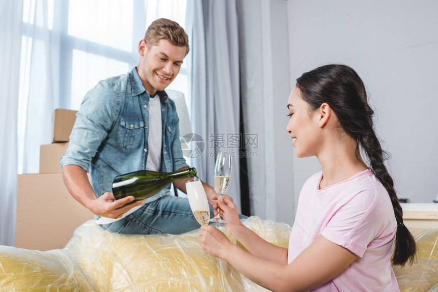快乐的一对年轻夫妇庆祝与香槟图片