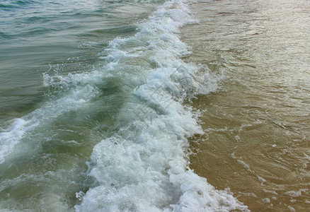 沙滩上有泡沫的海波软焦点图片