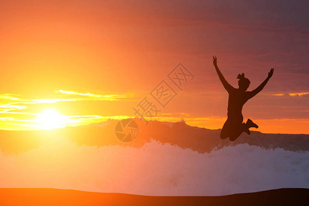 一个女孩在日落时跳跃的美丽剪影图片
