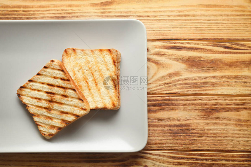 木桌上烤面包的盘子图片