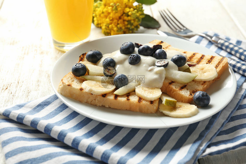 奶油水果和盘上蓝莓的美味甜烤面包图片