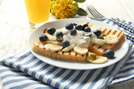 奶油水果和盘上蓝莓的美味甜烤面包图片