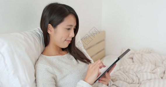 女人在床上看平板电脑图片
