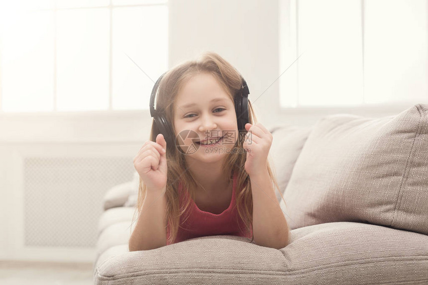 快乐的小女孩在耳机里听音乐图片
