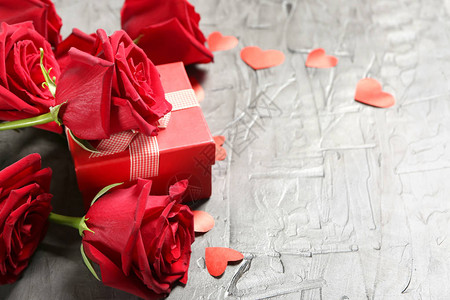 美丽的玫瑰和浅色背景的礼品盒图片
