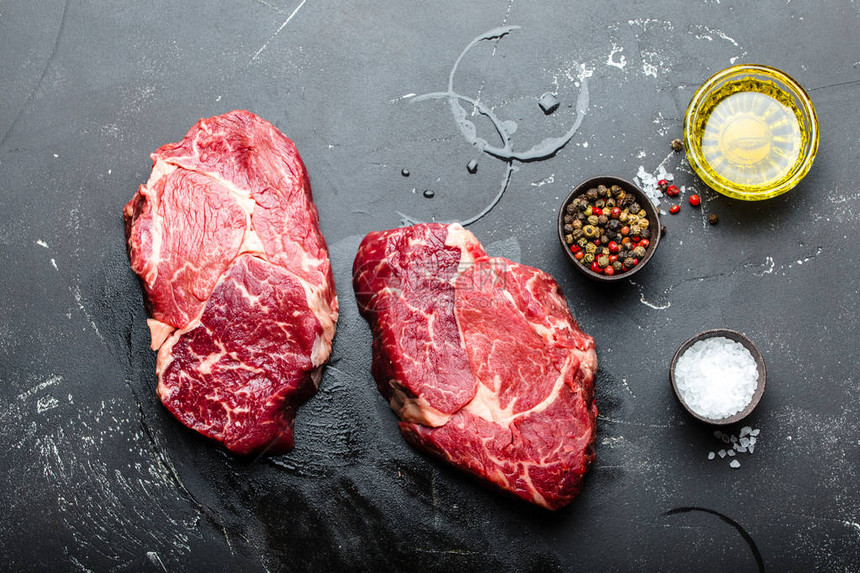 黑锈石背景的粗大理石鲜肉牛排里贝Ribeye调味品煮饭用的橄榄油烧烤烧烤或BBQ派图片