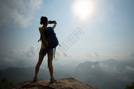 在日出山顶拍照片的成功女图片