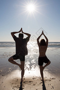 浪漫情侣在海滩上做瑜伽在色彩多图片
